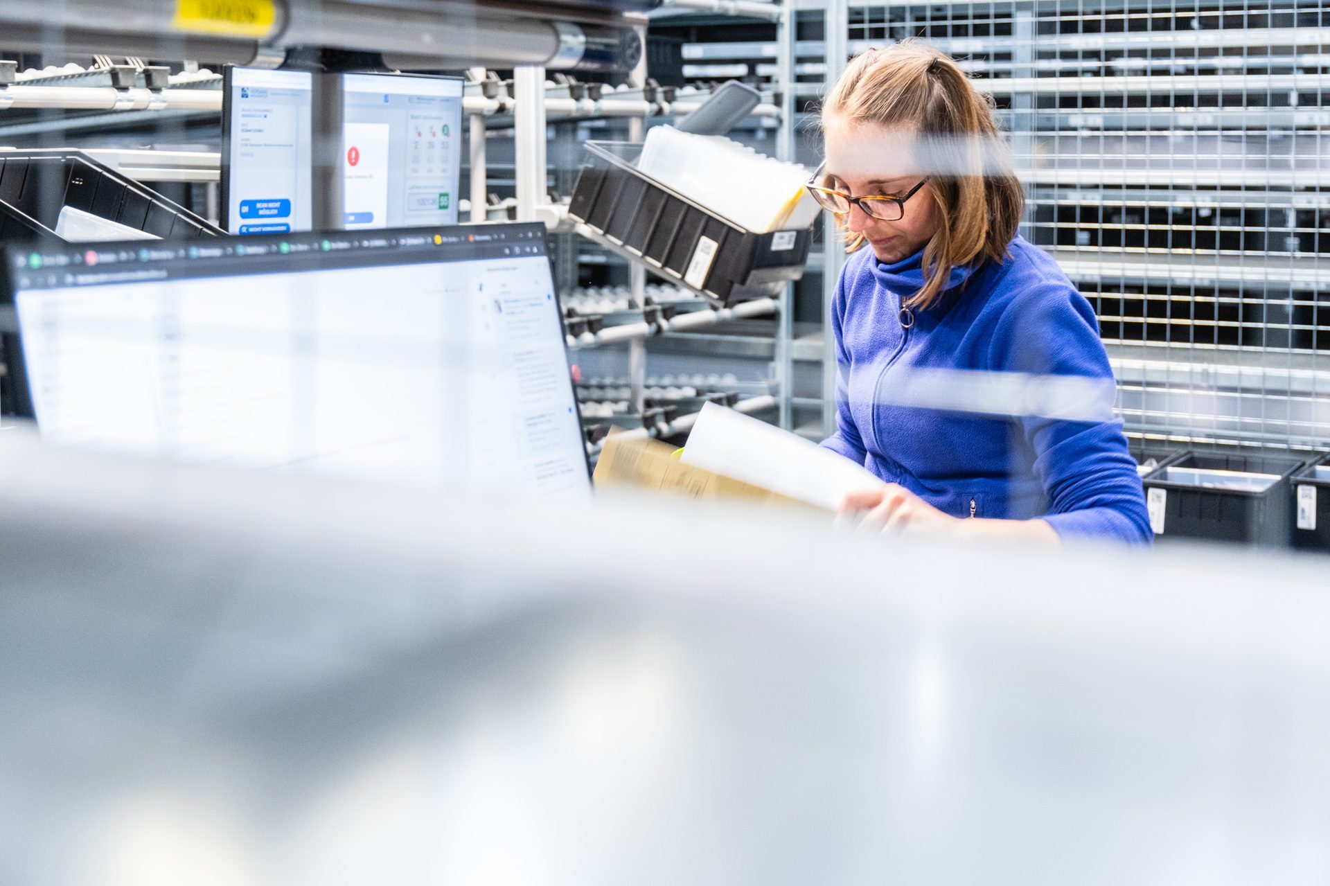 Conrad Electronic Mitarbeiter bei manueller Kommissionierung im Fachbodenregal